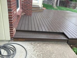 Dark stained deck with one step leading up