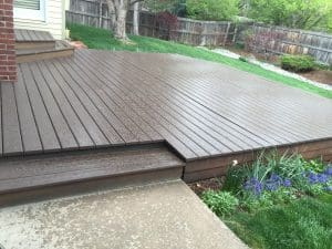 Dark stained deck with one step leading up