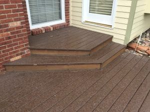 Dark stained deck, step, and landing to a door