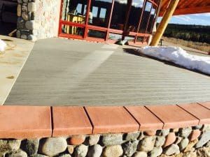 Wood decking cut around rocks, and edged with pavers