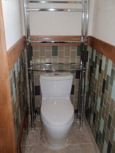 Tiled vertically with oak trim toilet recessed area.