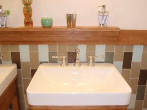 White sink, vertically tiled backsplash with oat ledge