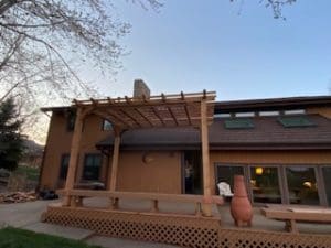Back view towards the back of house small deck with arbor